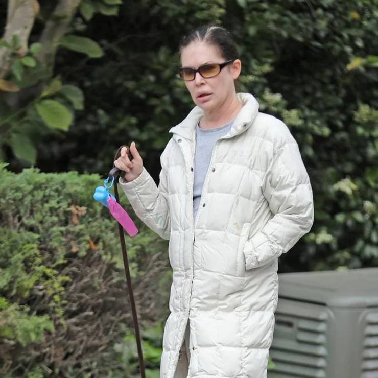 lara flynn boyle wakende hond buiten met witte jas